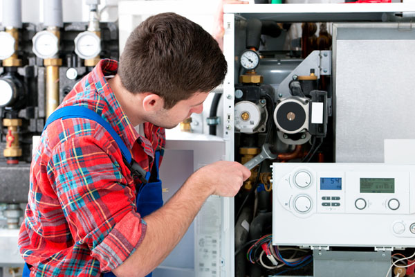 Heating technician repairing boiler controls in San Bruno