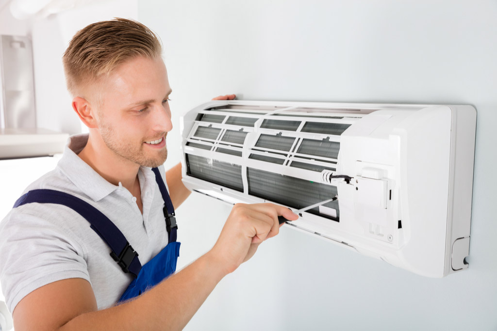 HVAC technician maintaining a ductless air conditioner in San Bruno