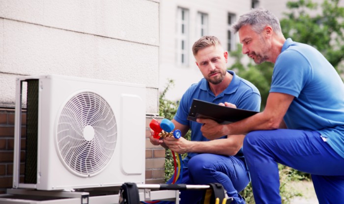 HVAC technicians installing an outdoor air conditioning unit in San Bruno